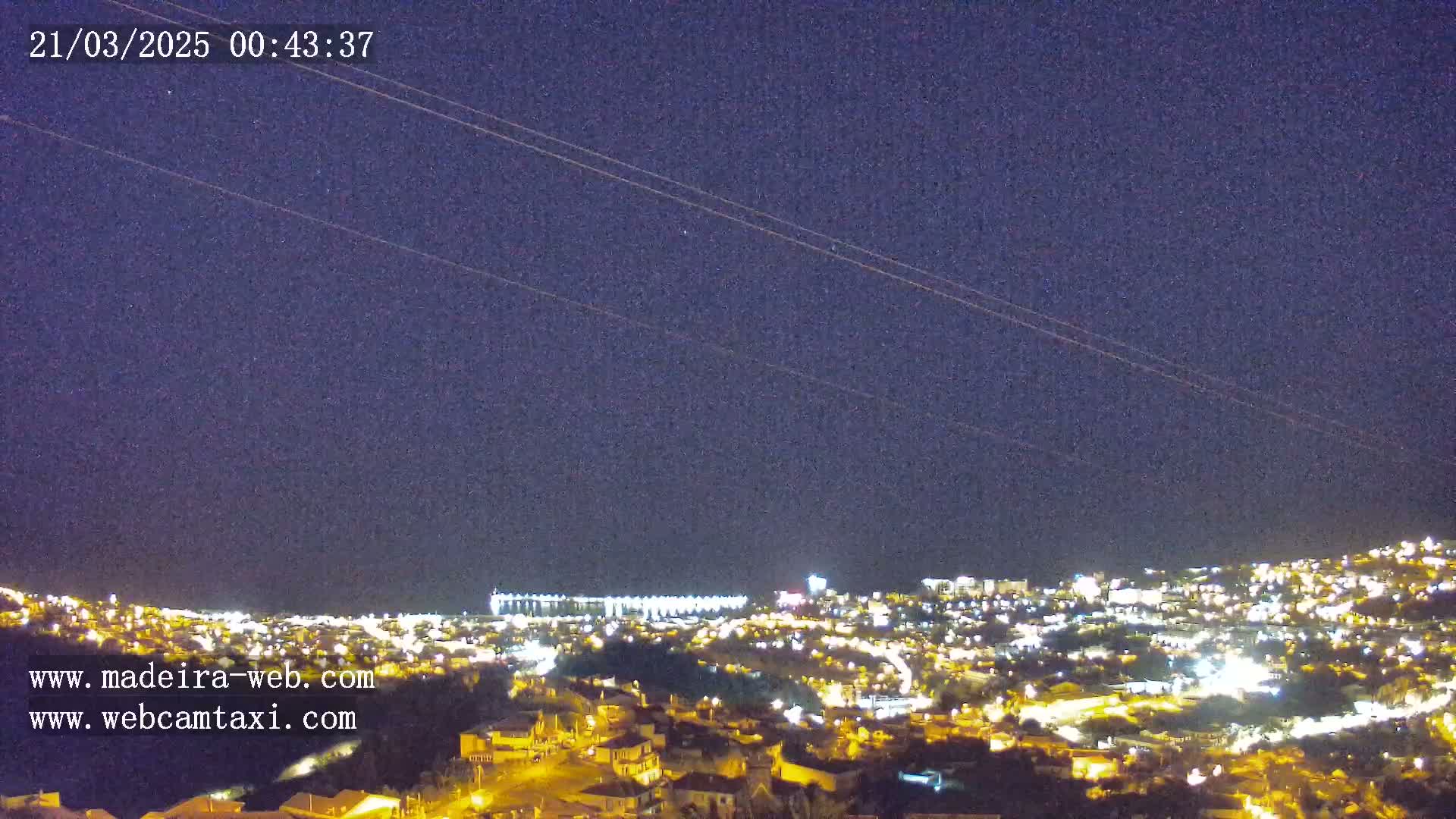 A nighttime view of a city illuminated by lights under a clear, dark sky.