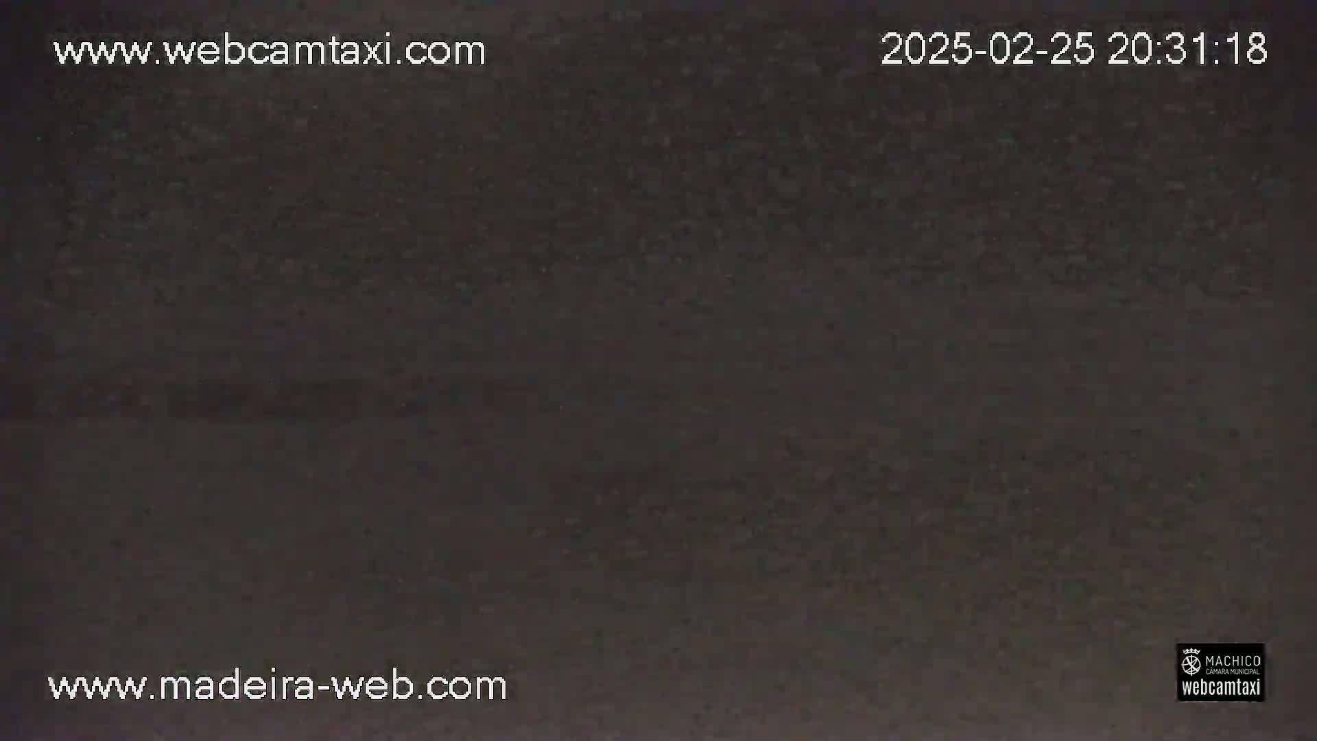 A dark, grainy image shows a nighttime outdoor scene under unclear weather conditions.