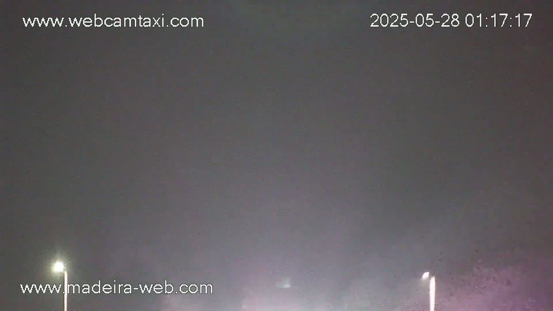 A dark, nighttime scene shows two distant lights illuminating a slightly hazy atmosphere.