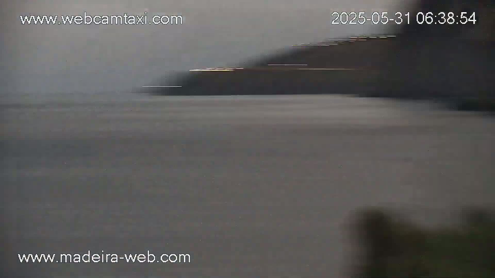 A blurry image shows a dark, overcast sky and a flat expanse of gray water.
