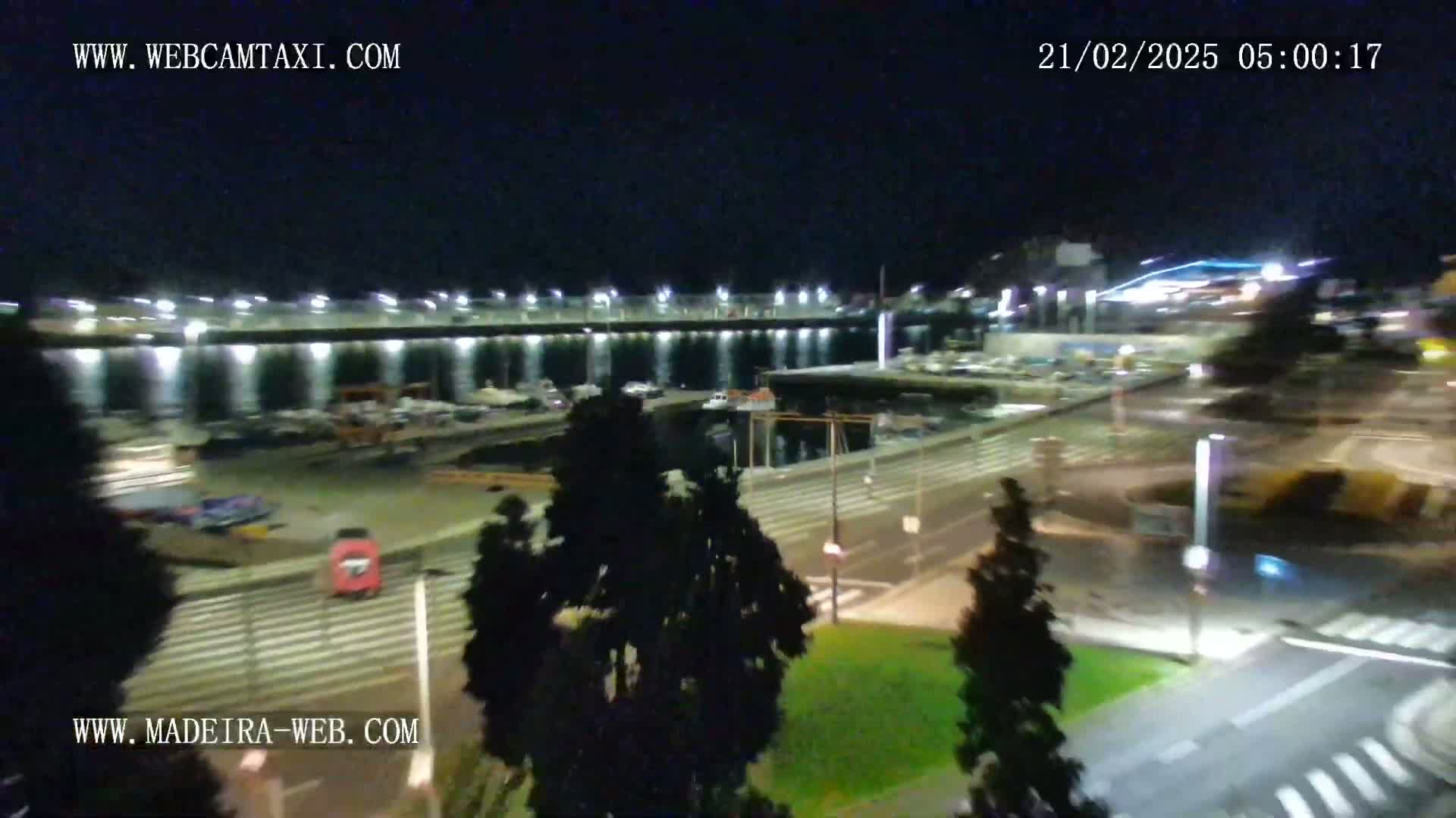 A nighttime, aerial view of a harbor and city streets with minimal traffic.