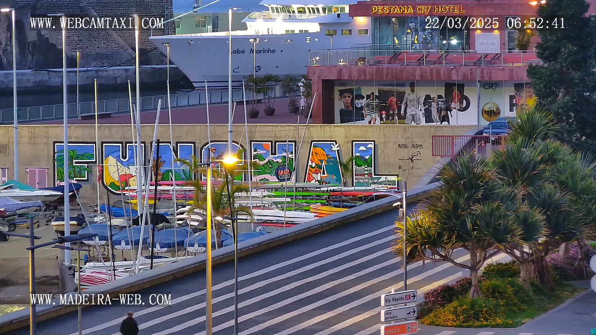 A harbor scene at dawn shows a large mural of the word "FUNCHAL" on a building, numerous boats docked, and a cruise ship in the background.