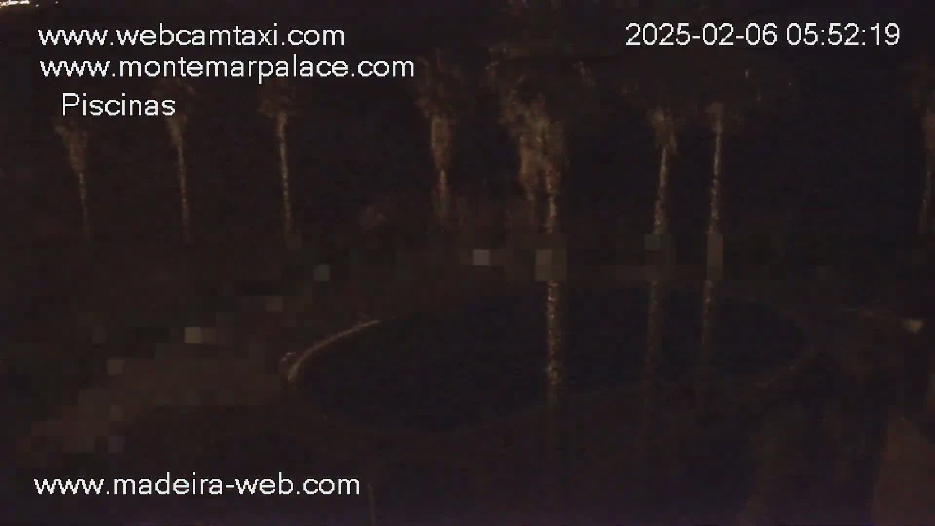 A nighttime, dark view shows what appears to be a pool area with indistinct shapes and vertical streaks of light.
