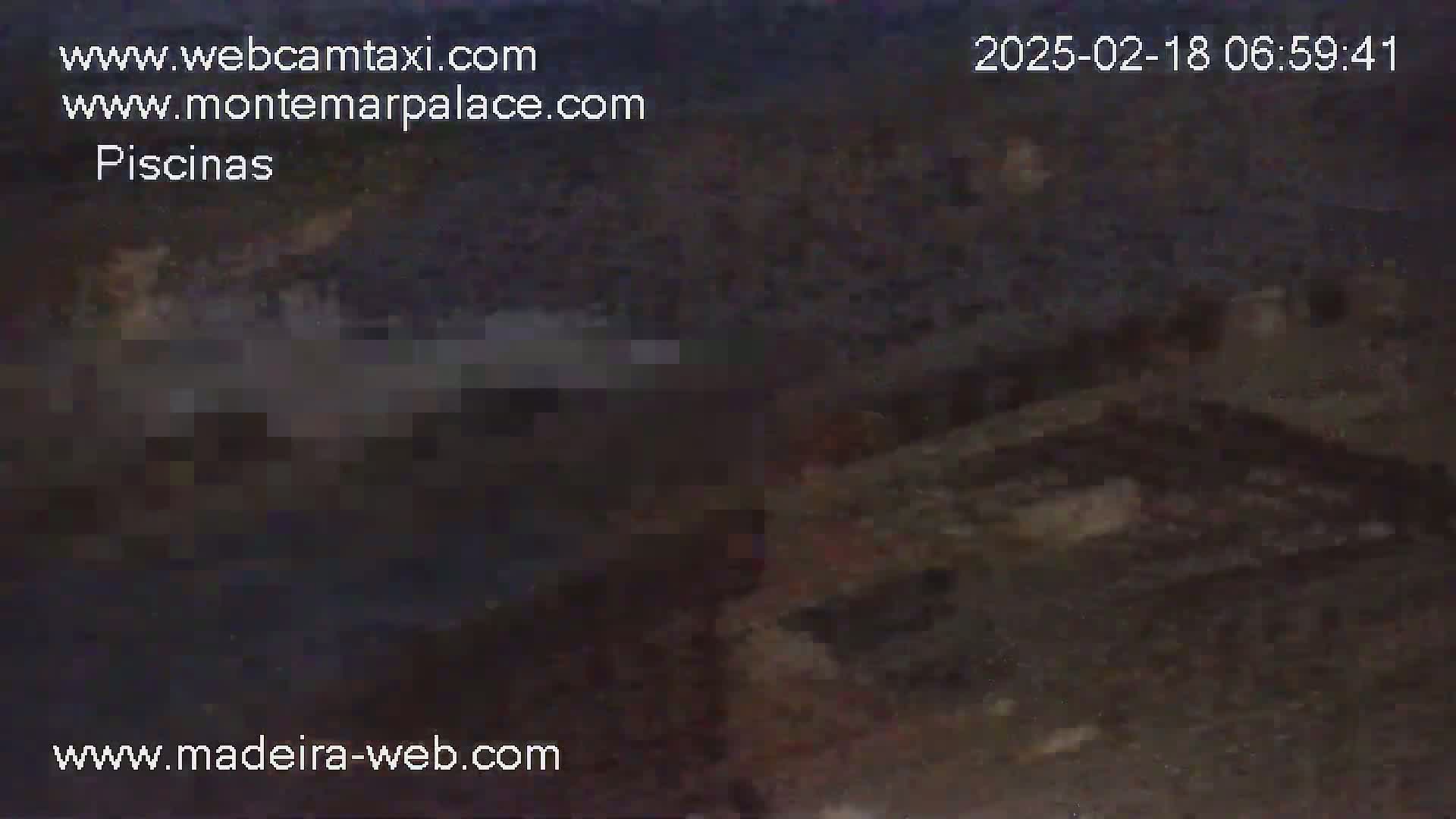 A dark, blurry nighttime image shows an indistinct outdoor scene with what appears to be a body of water.