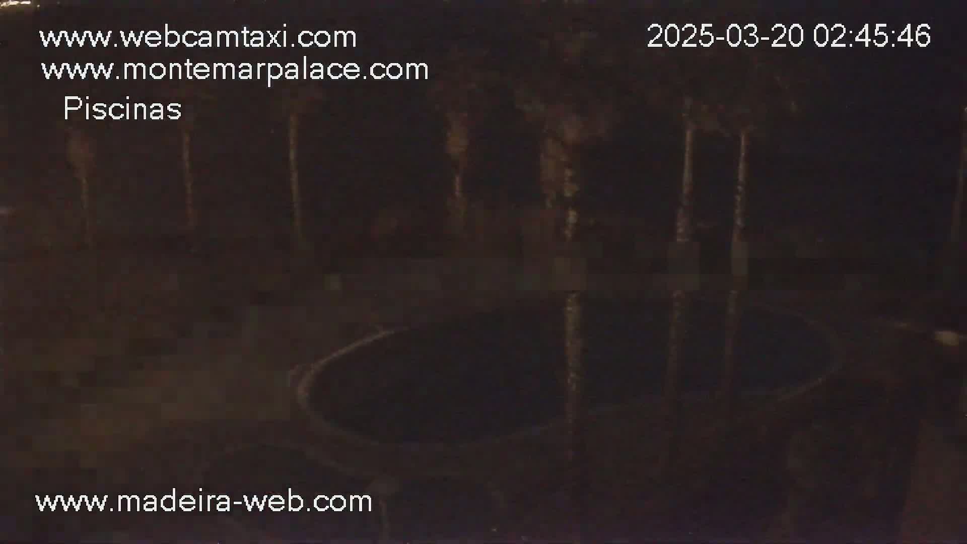 A nighttime, low-light view of a dark, circular pool or basin surrounded by indistinct features.