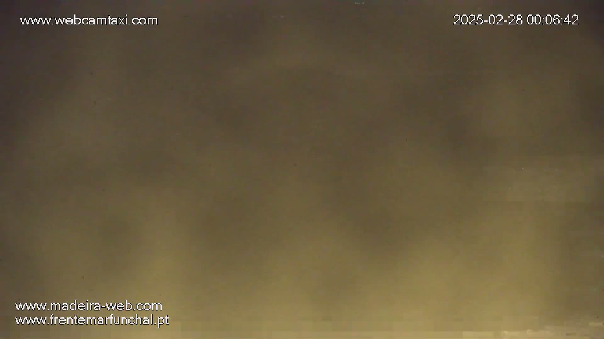 A blurry, muted-brown image shows a hazy or dusty outdoor scene.