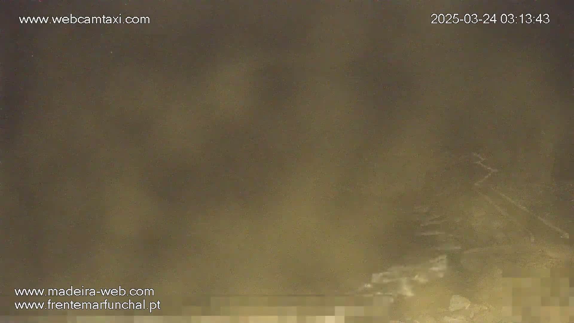 A blurry, dark image shows a hazy, possibly foggy or dusty, night scene.