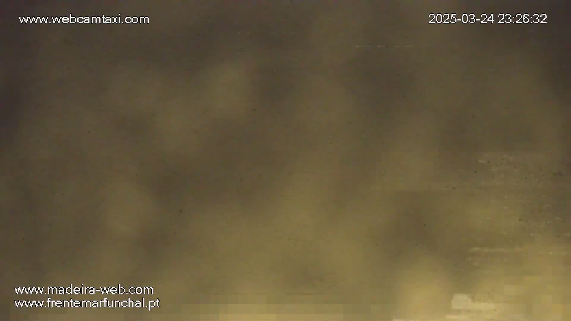 A hazy, muted-brown image shows an indistinct outdoor scene at night.