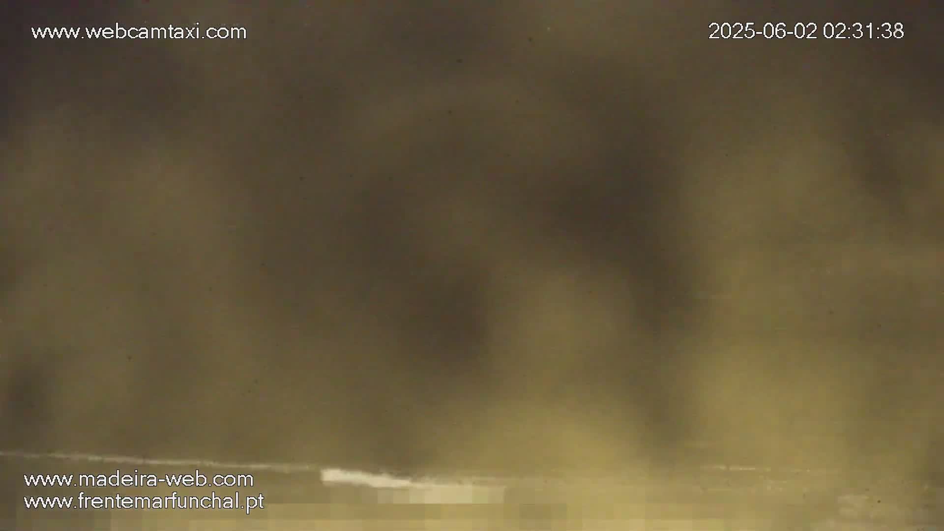A hazy, muted-brown image shows a blurred, indistinct view of what seems to be an outdoor scene at night.