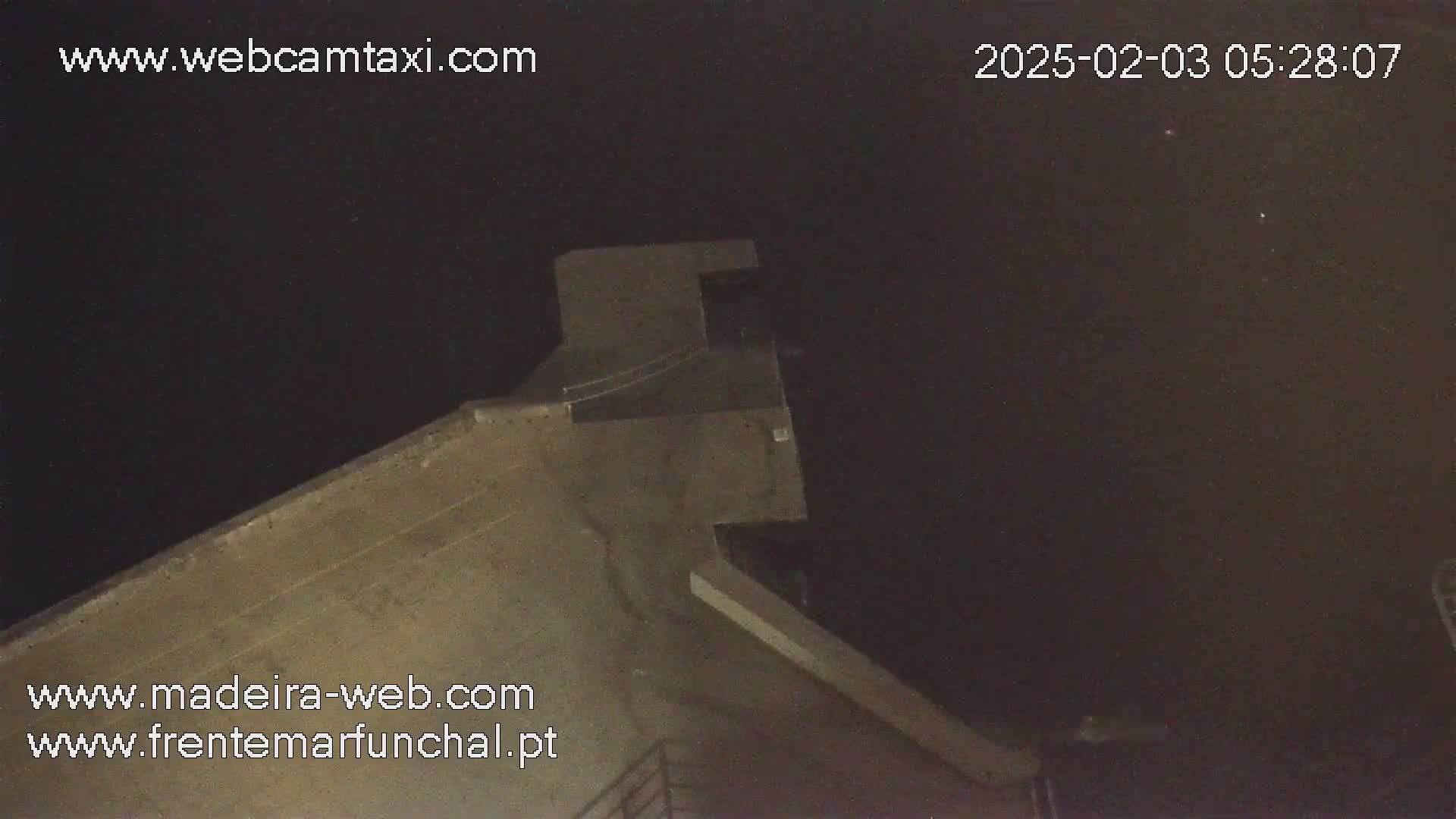 A high-angle, nighttime view shows a concrete structure under a dark sky.