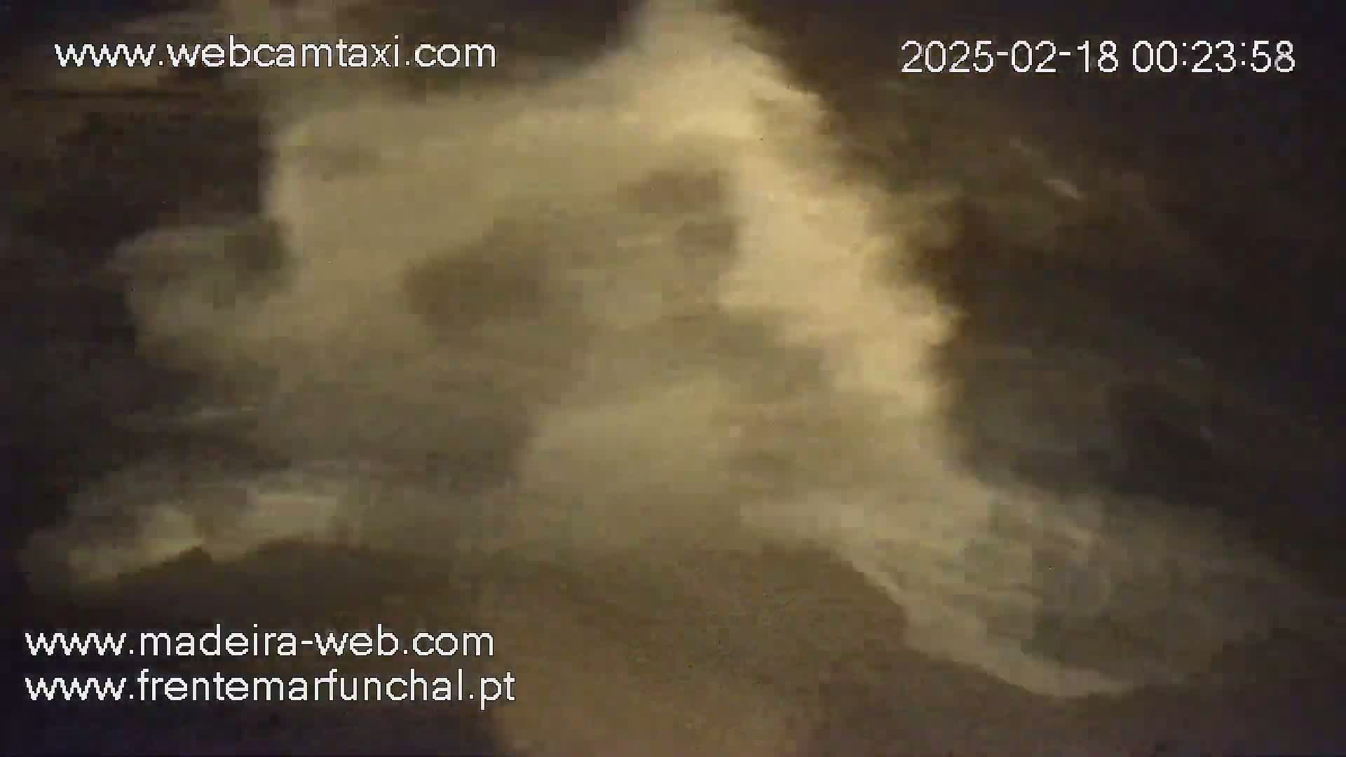 A blurry, nighttime image shows a hazy, light-brown cloud formation obscuring the view.