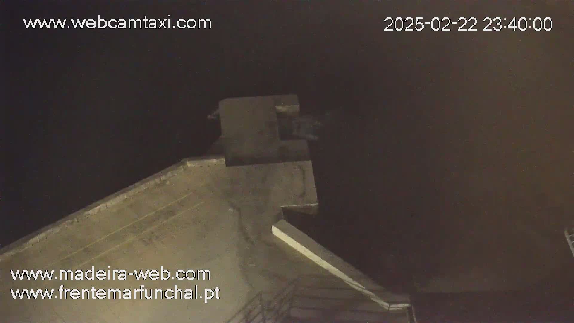 A high-angle nighttime view shows a section of a concrete structure under a dark sky.