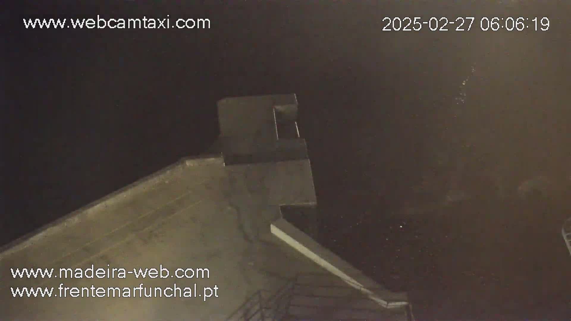 A nighttime view of a building's rooftop under a dark sky.