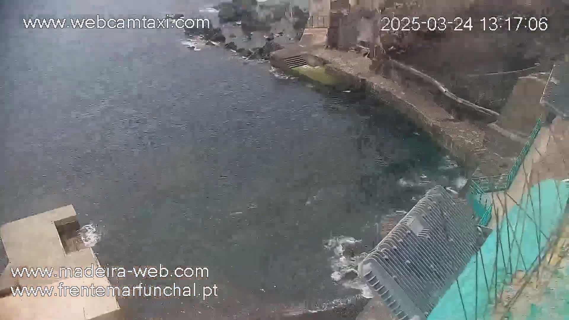 A dark body of water flows near a stone structure, with a metal grate-like object partially submerged.