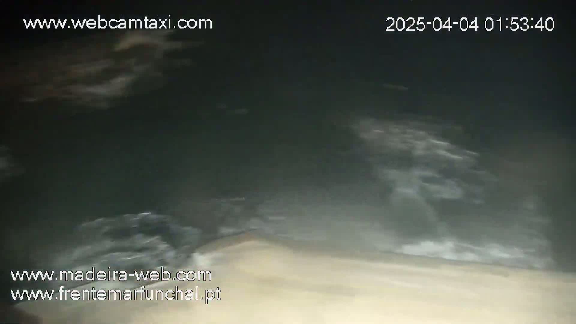 A nighttime, blurry view of dark, churning water.