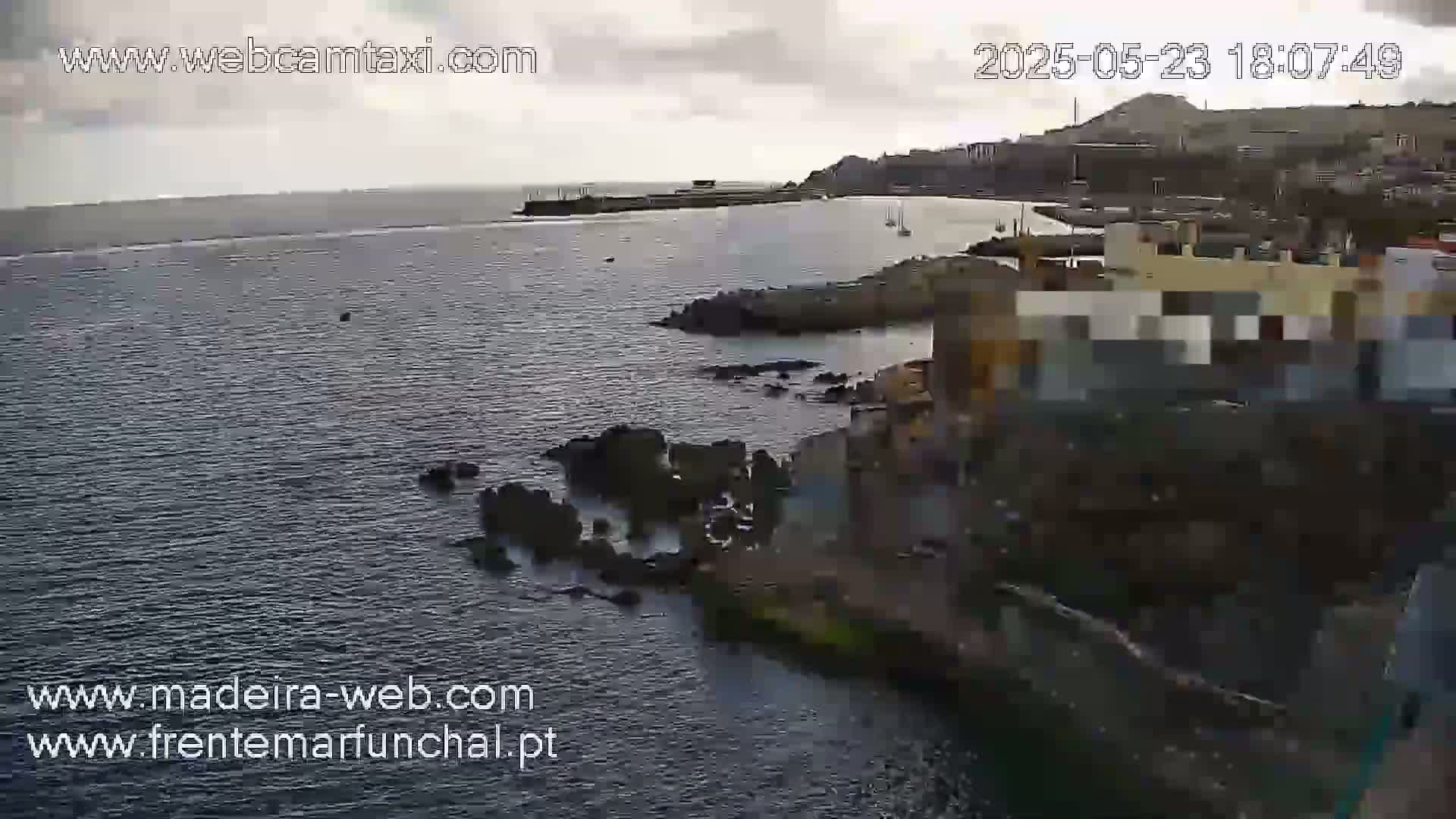 A high-angle view shows a rocky coastline with dark, overcast skies over a body of dark water.
