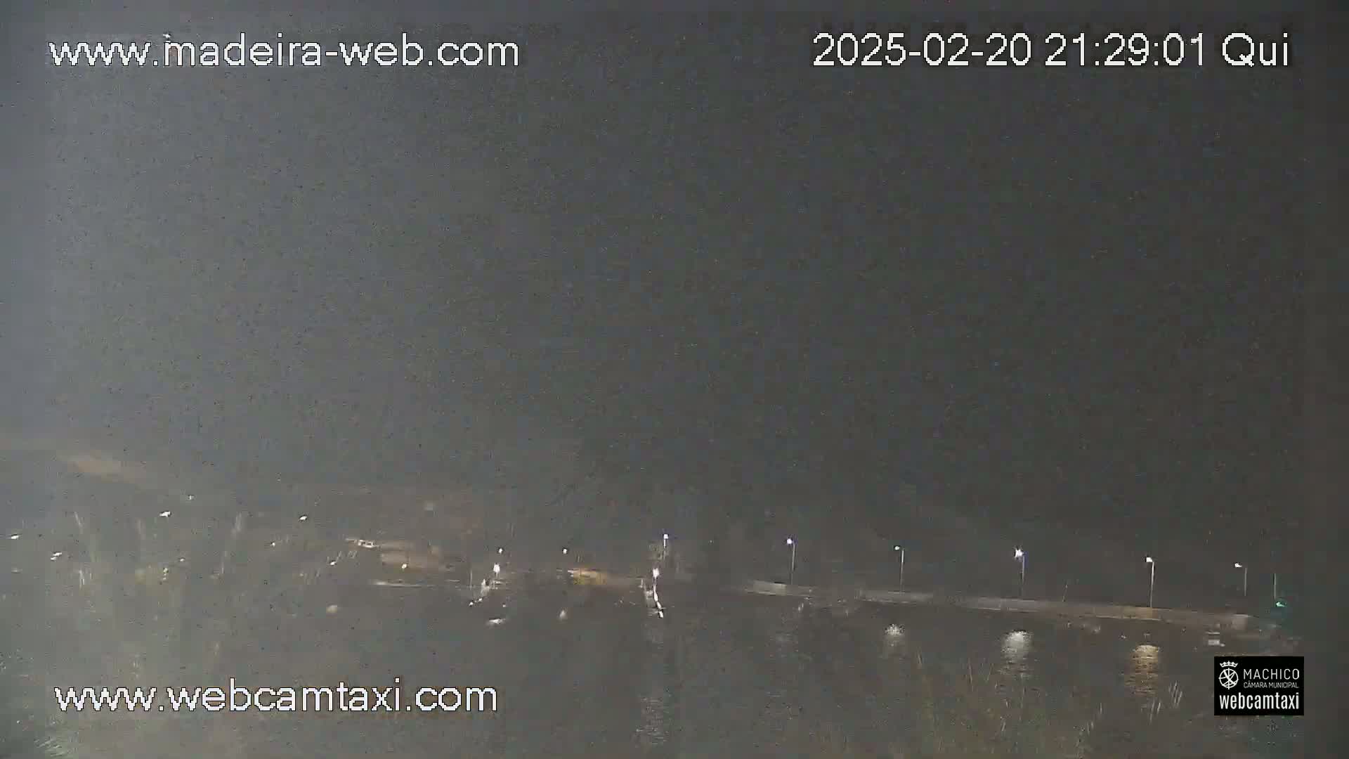 A nighttime, hazy view of a body of water with lights along a shoreline.