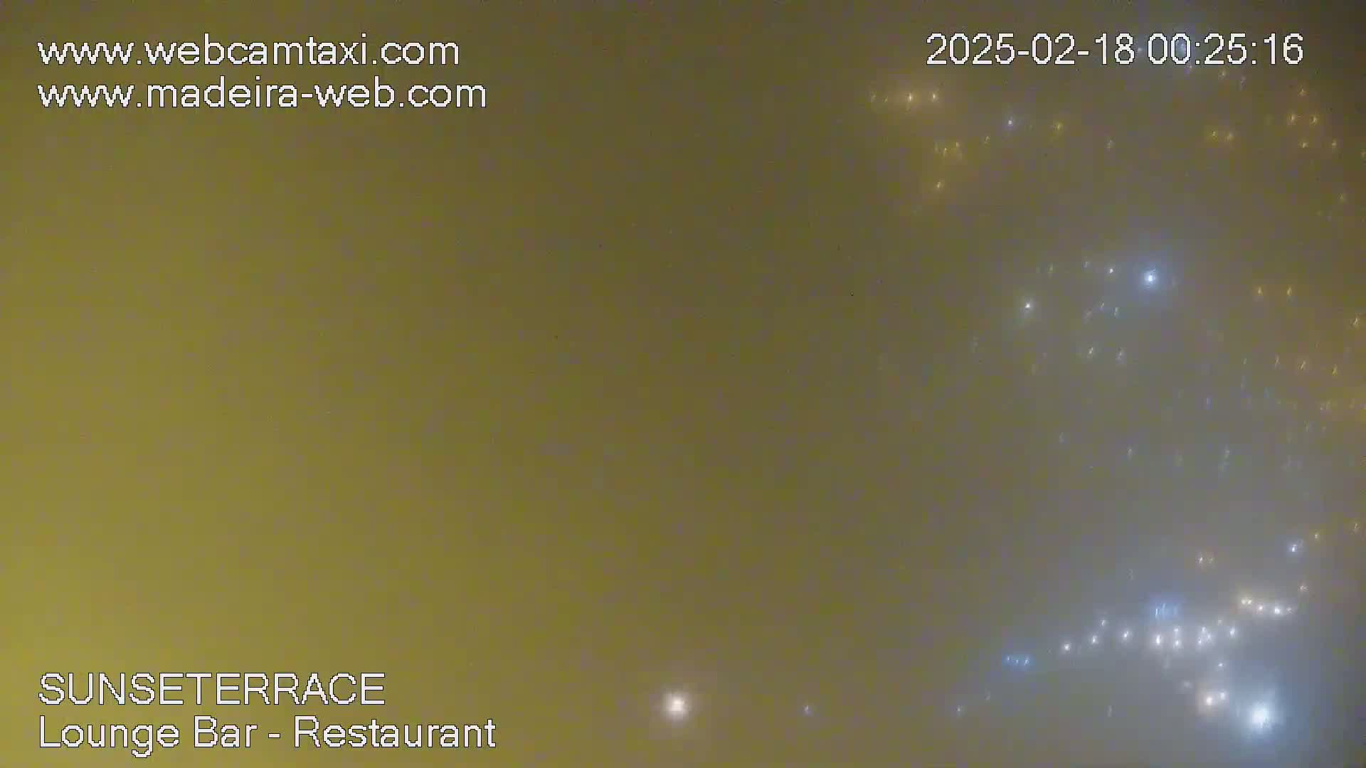 A hazy, muted-yellow night sky speckled with distant lights.