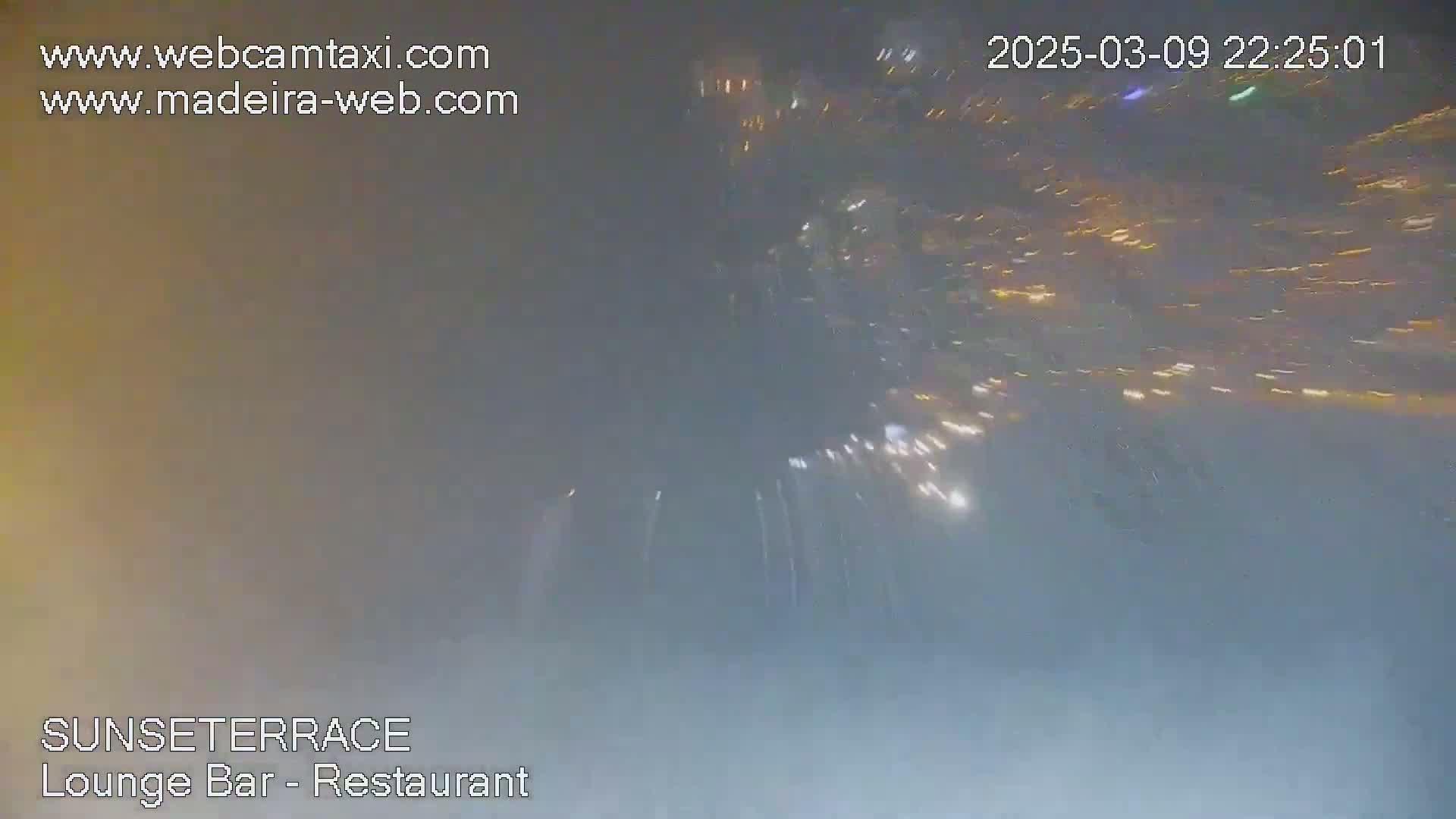 A hazy night scene shows a blurred view of distant lights appearing as streaks.