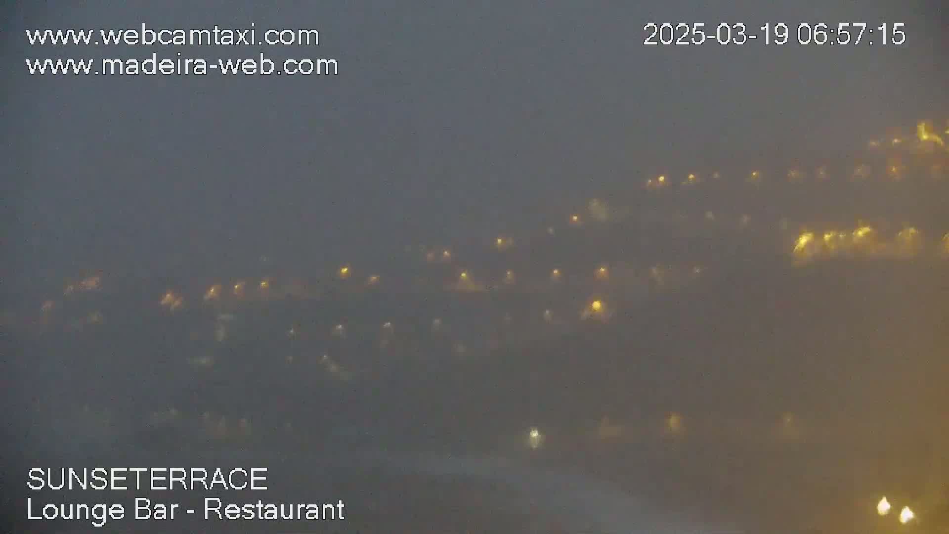 A hazy, foggy view of numerous faint lights at night.