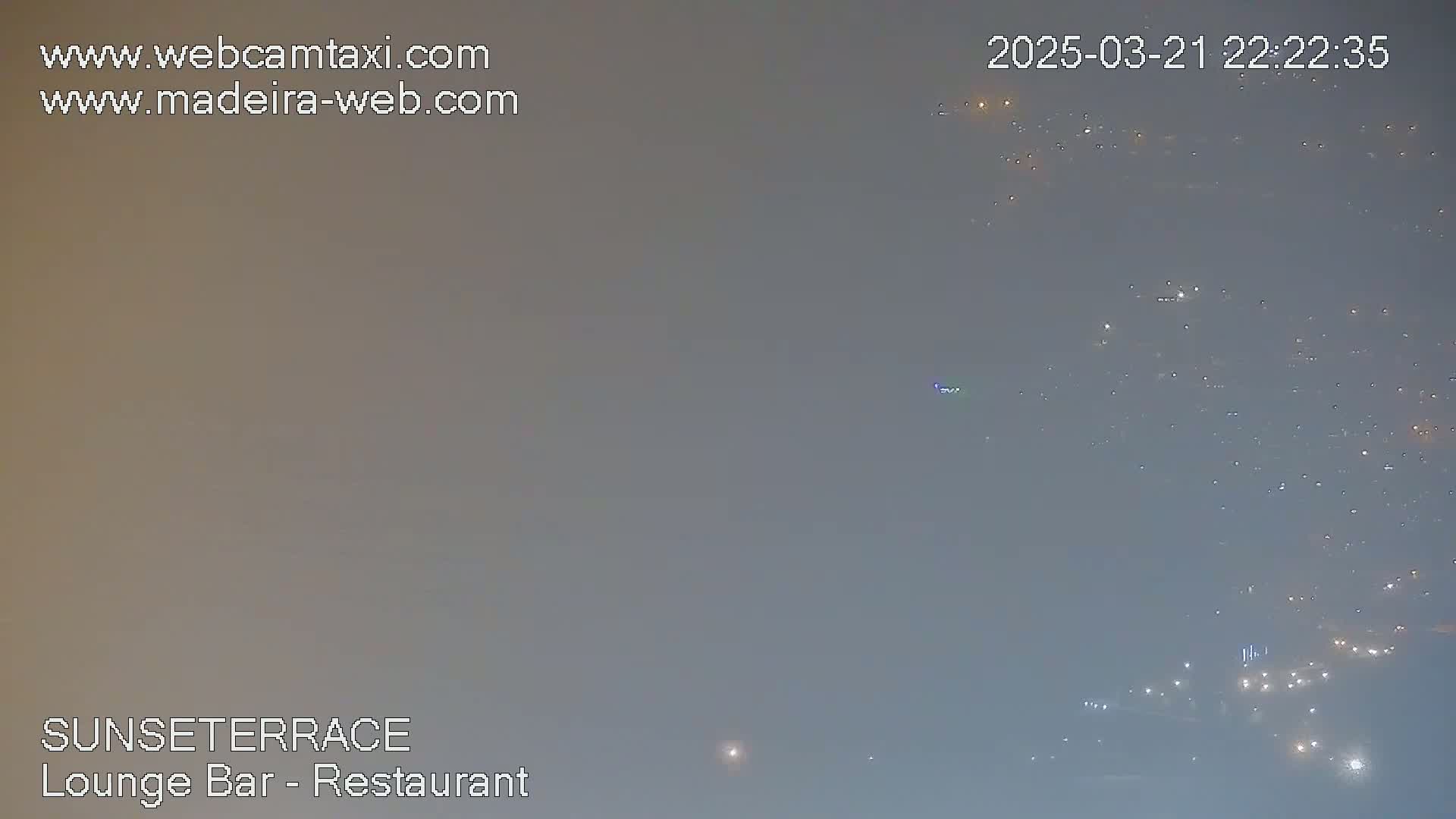A hazy, nighttime view of distant city lights.