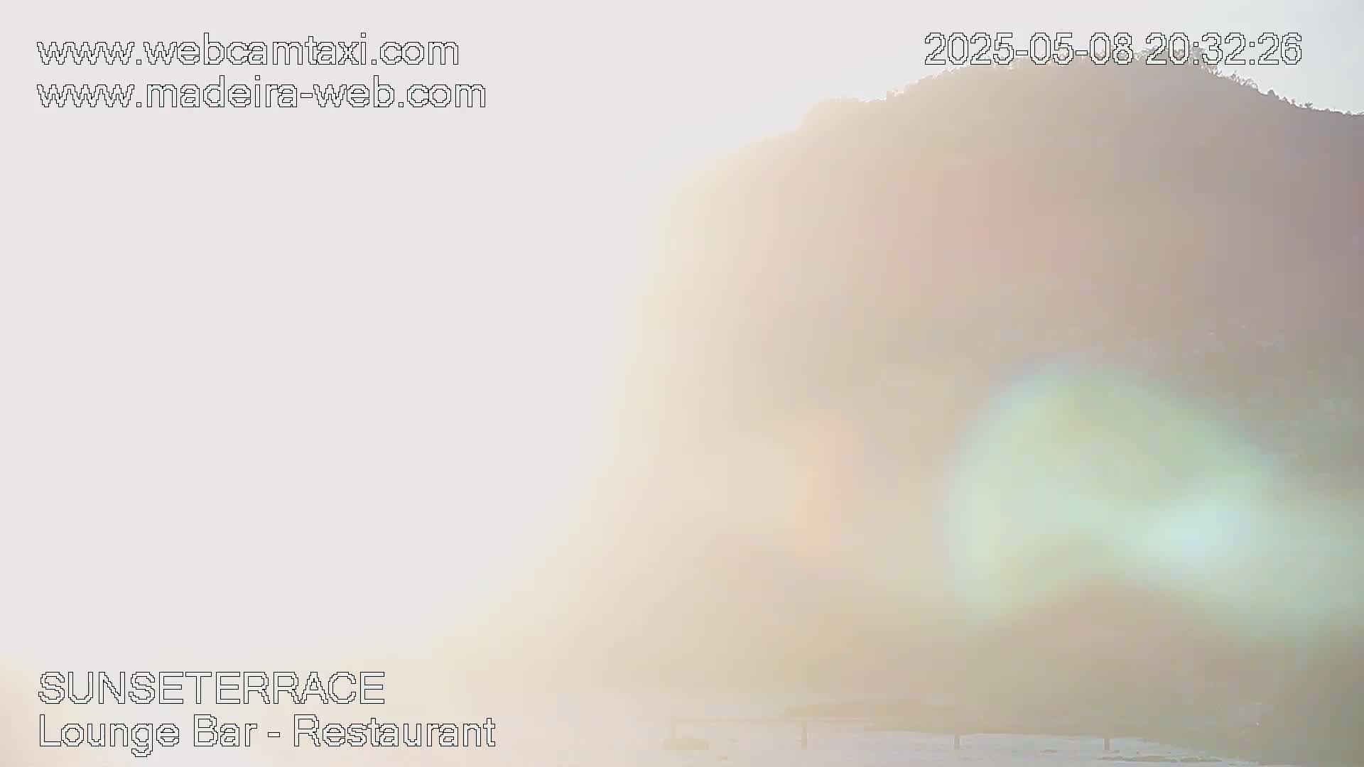 A hazy sunset illuminates a distant hill.