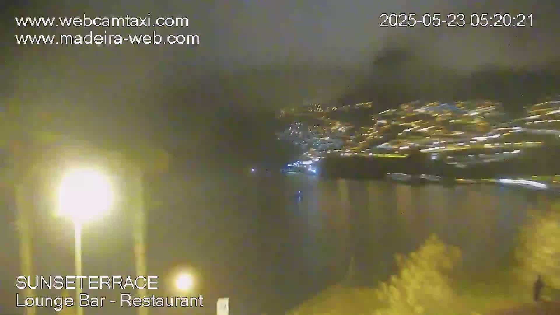 A nighttime, hazy view of a city's lights across a body of water.