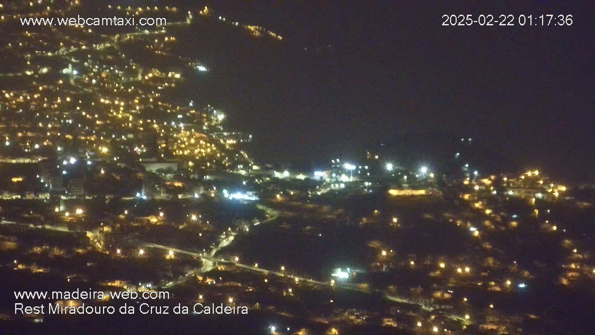 A nighttime aerial view of a town illuminated by many small, scattered lights.