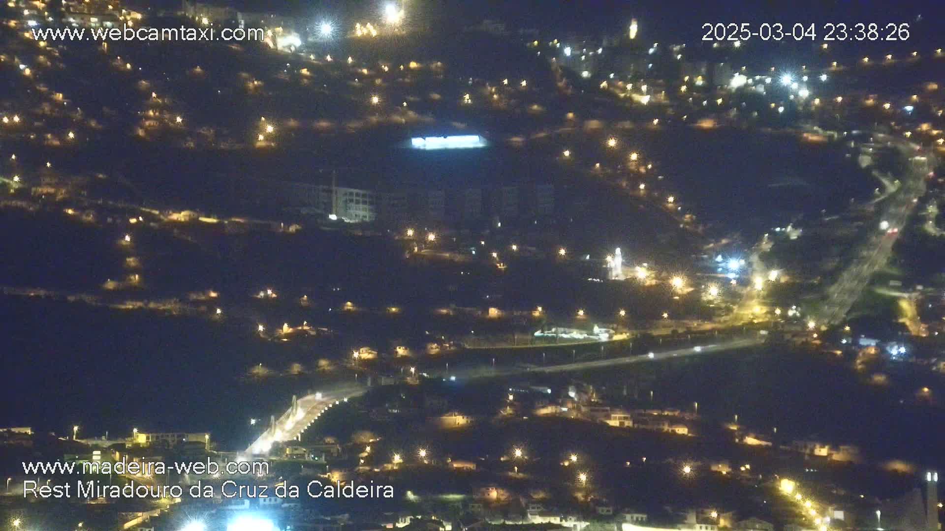 A nighttime, aerial view of a town illuminated by scattered streetlights.