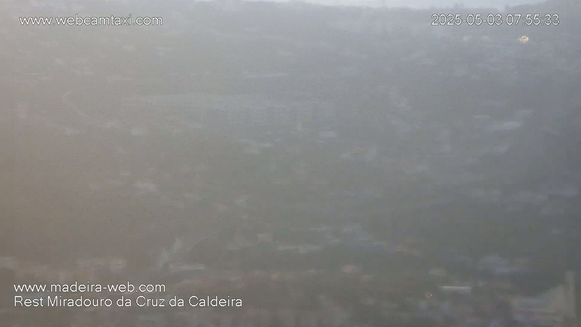 A hazy, distant view of a landscape, possibly a town or city, is visible under foggy or misty conditions.
