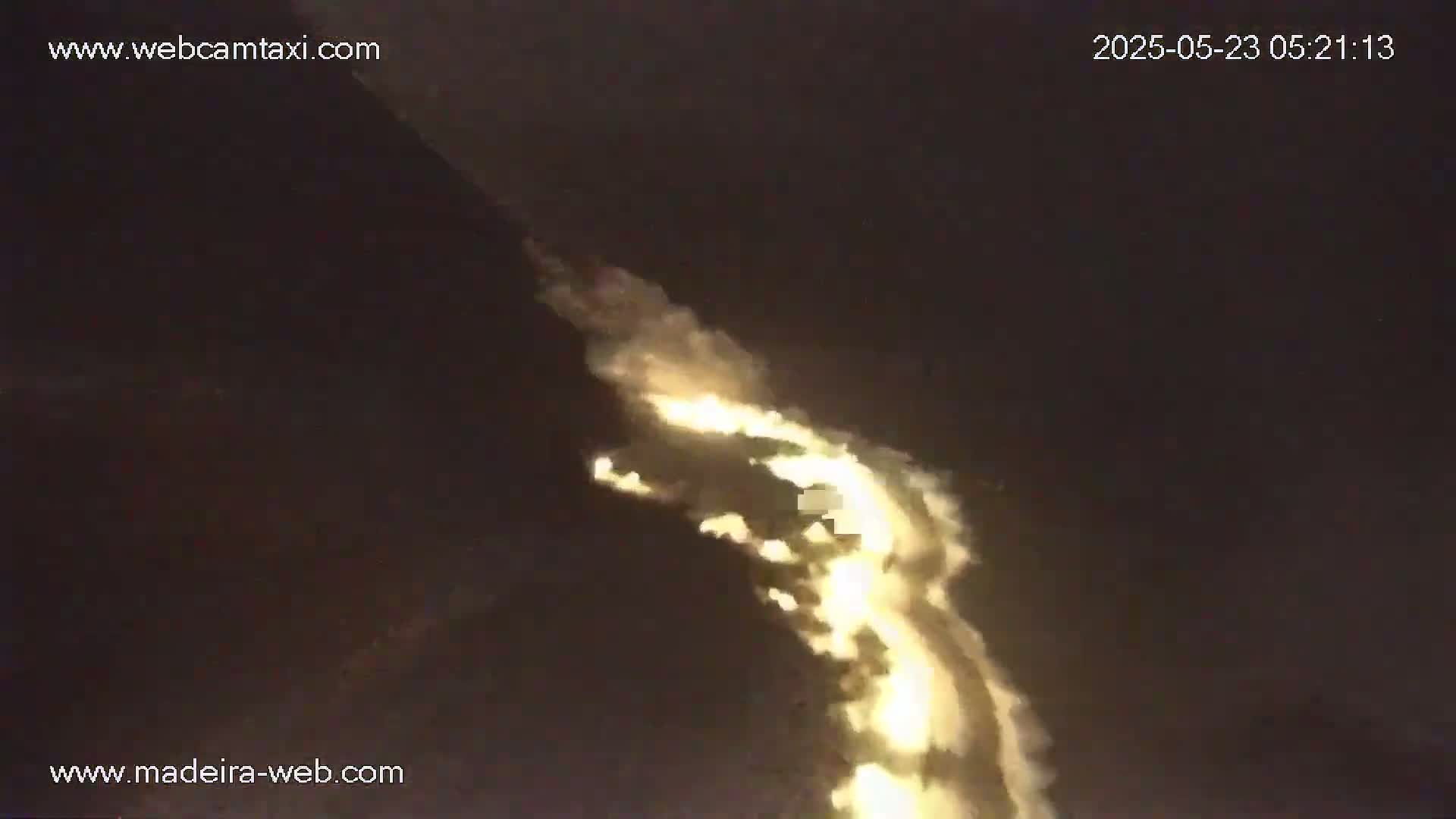 A long, glowing, cloud-like formation is visible against a dark night sky.
