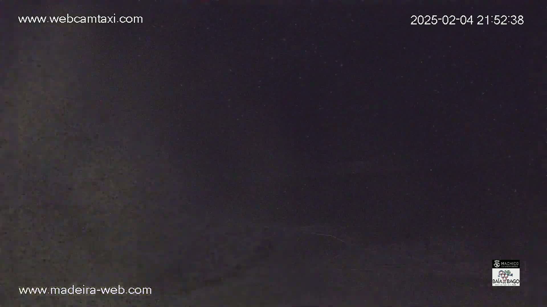 A dark, nighttime image shows a mostly clear, dark sky with a few specks of light.