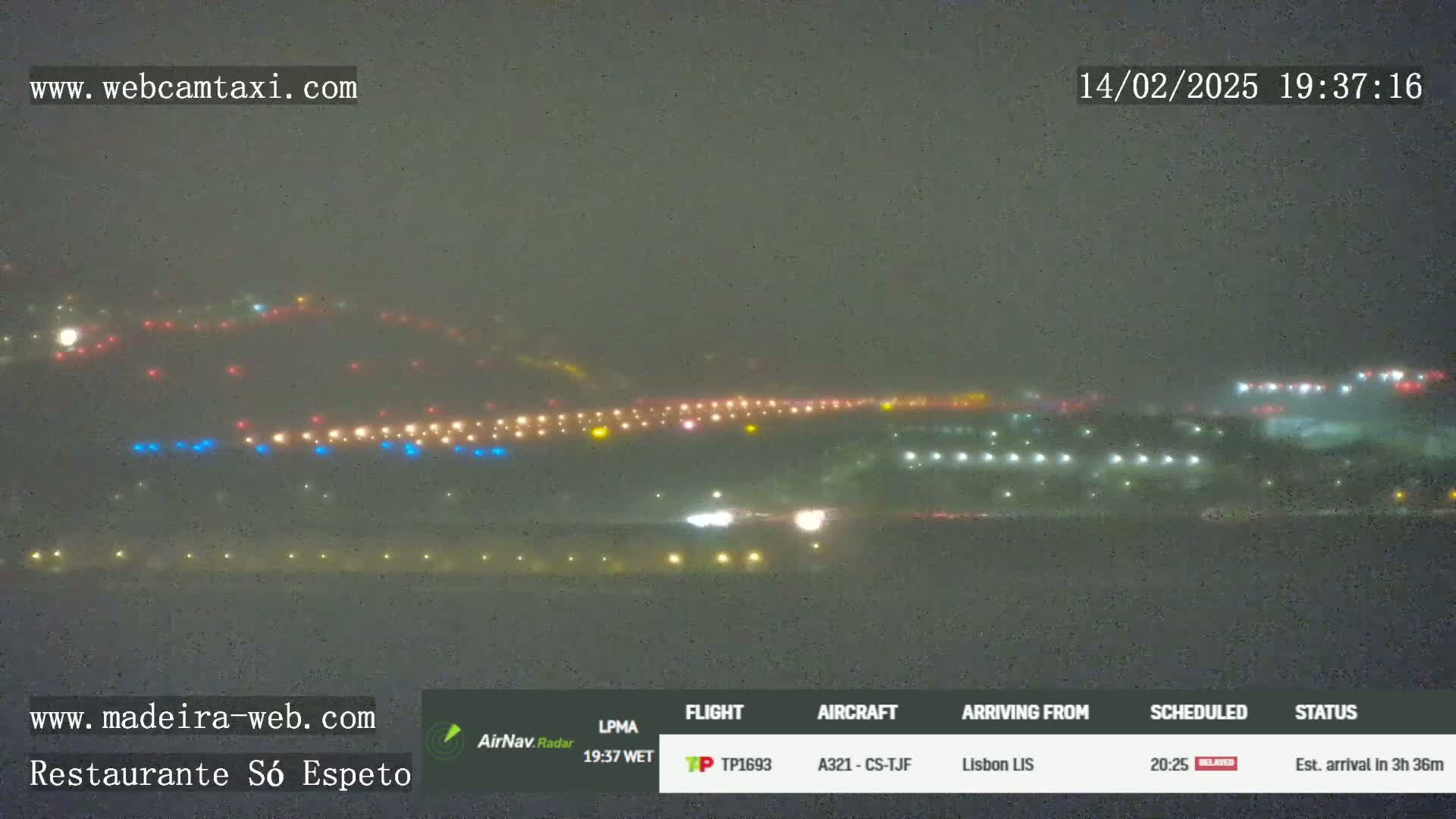 A hazy, nighttime view of an airport runway with numerous lights visible.