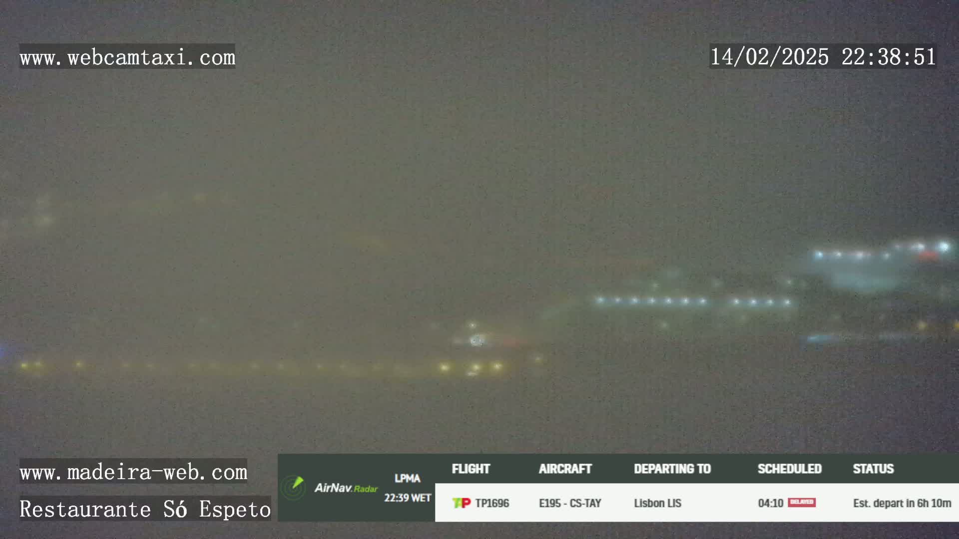 A hazy night scene shows a blurry line of lights, possibly from an airport runway, in the distance.