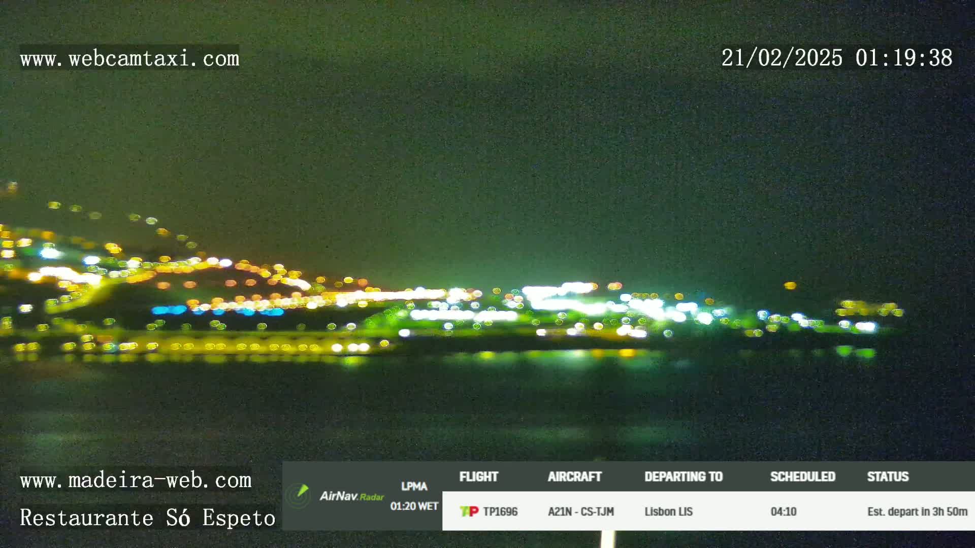 A nighttime view of a city's lights across a dark body of water under a clear, dark sky.