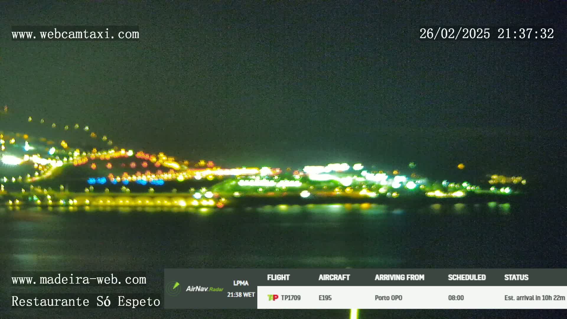 A nighttime long shot of a city's lights across a dark body of water.