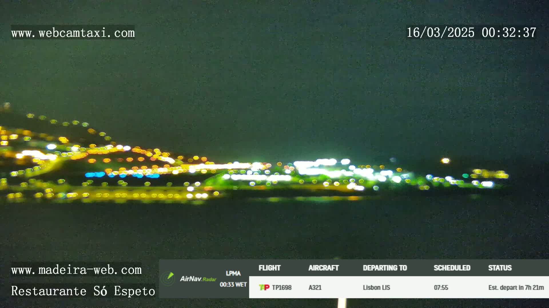 A blurry, nighttime view of a city's lights across a dark body of water.