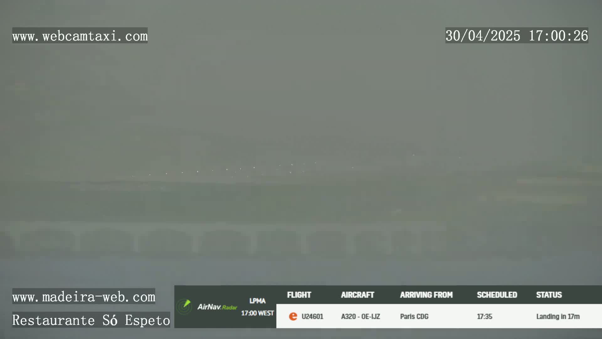 A hazy, outdoor scene shows a distant runway with faint lights visible through the fog.