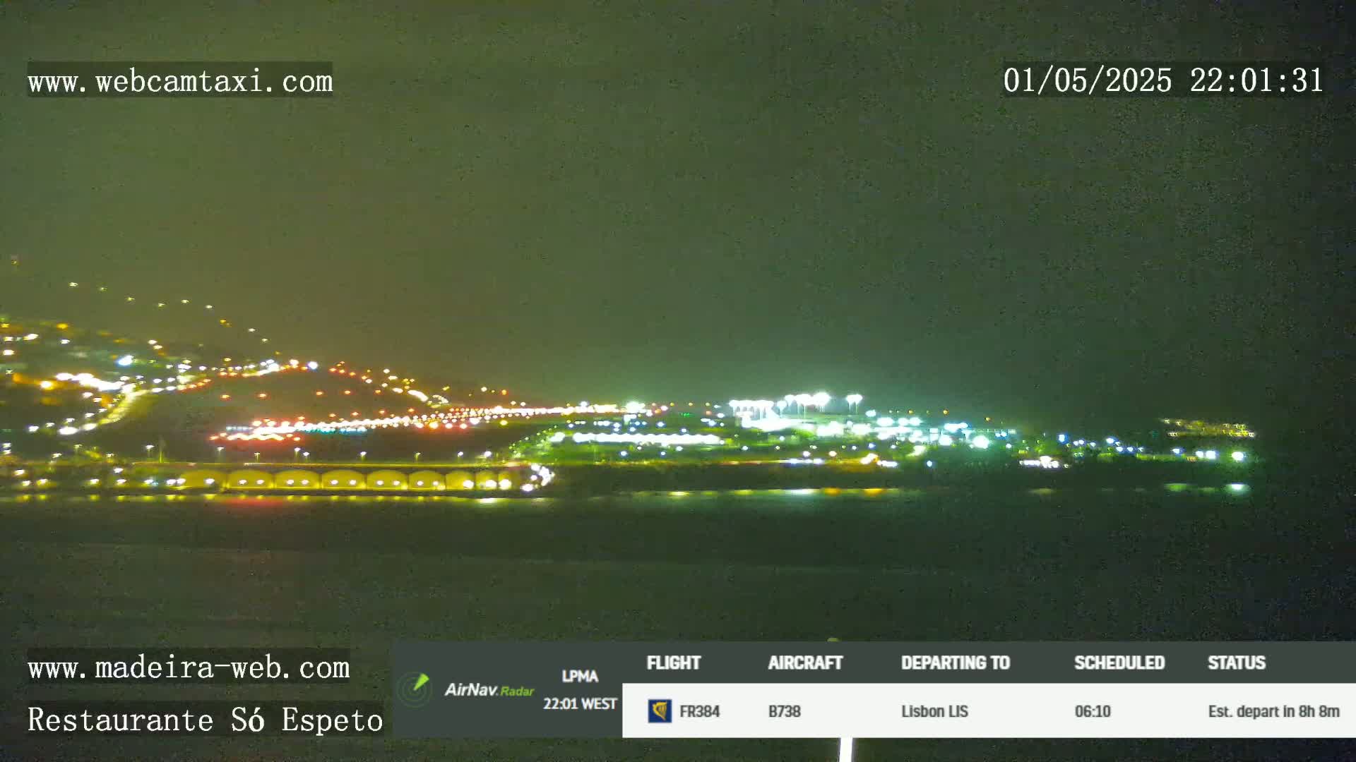 A nighttime view of an illuminated airport and surrounding area under a dark sky.