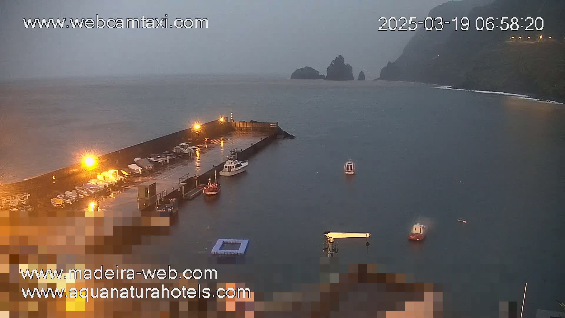 A wet harbor with several boats docked, under an overcast sky.