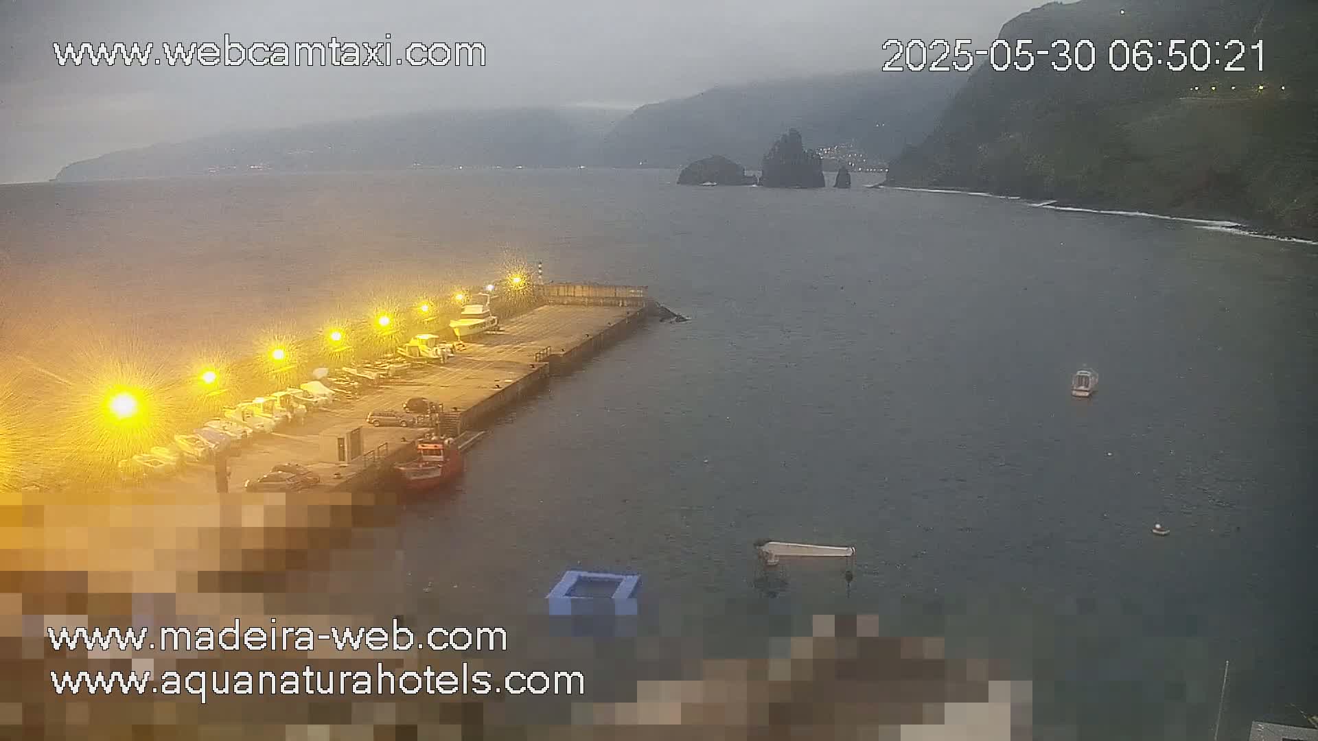 A harbor with several boats docked under an overcast sky.