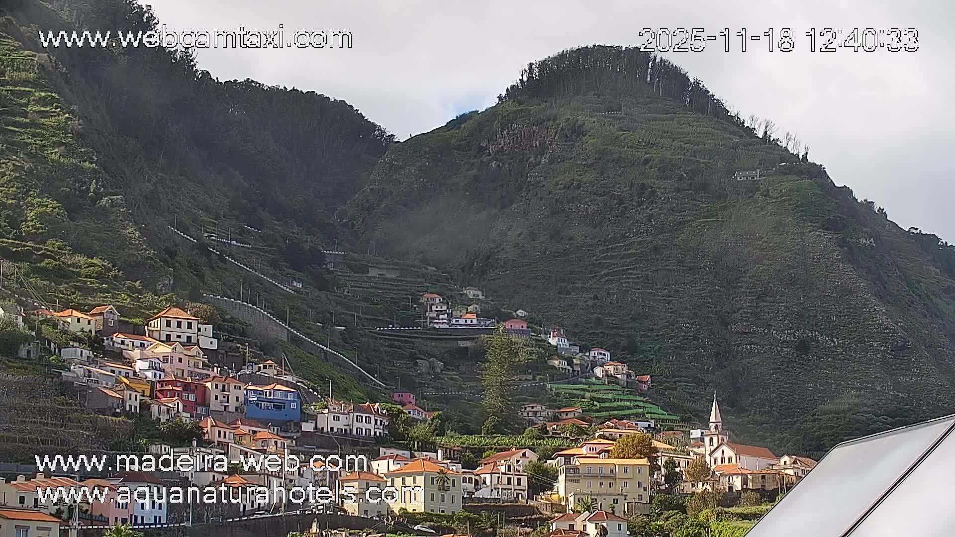 A hazy night scene shows a hillside town with illuminated buildings in the distance.