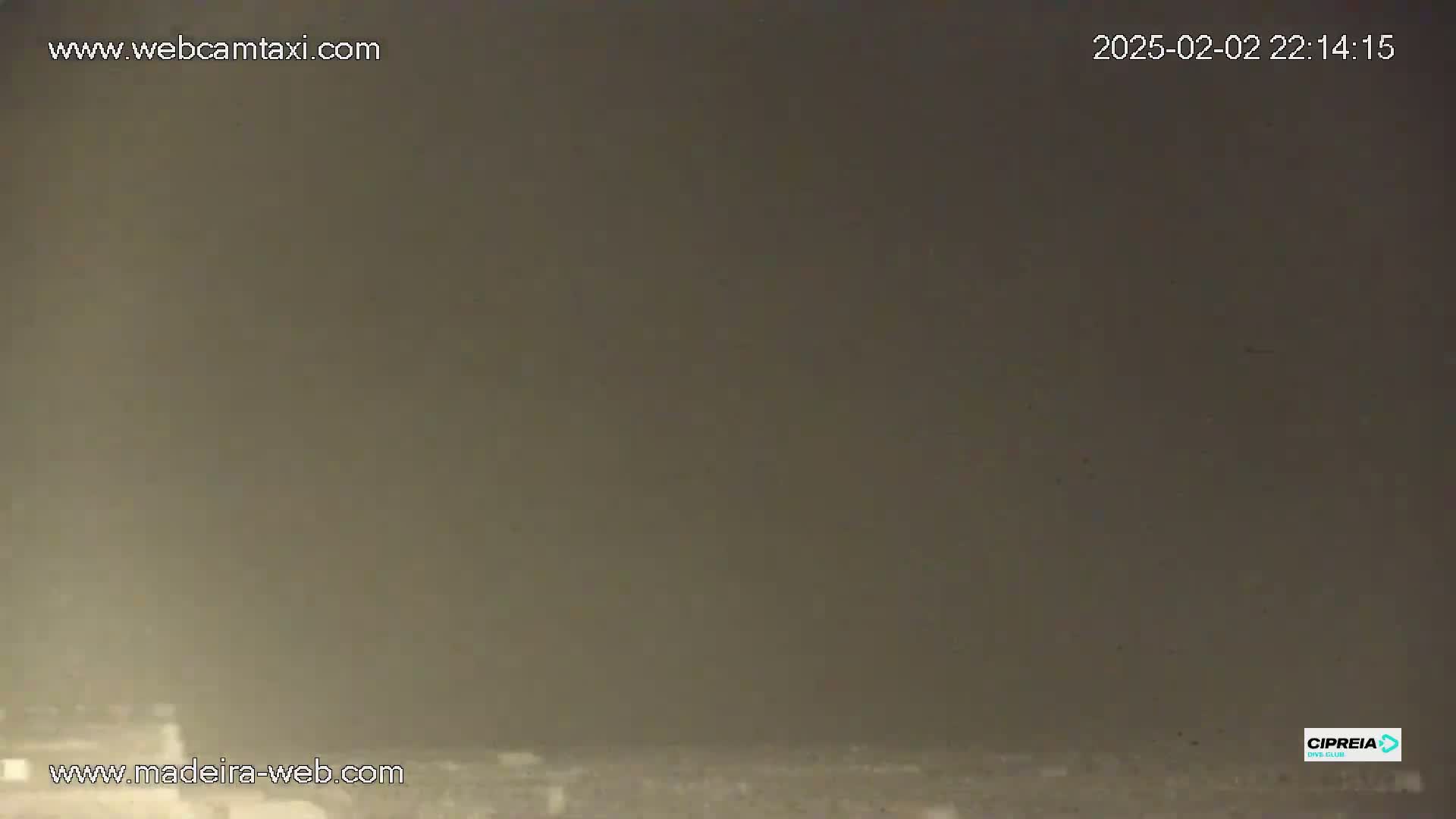 A hazy, dark-brown nighttime scene shows a low-lying expanse of land.