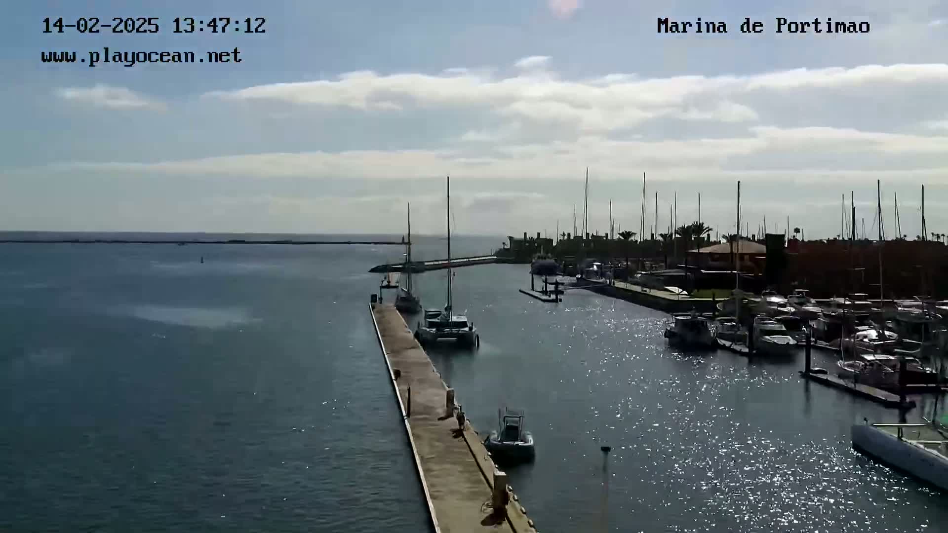 A marina filled with boats on a partly cloudy day.