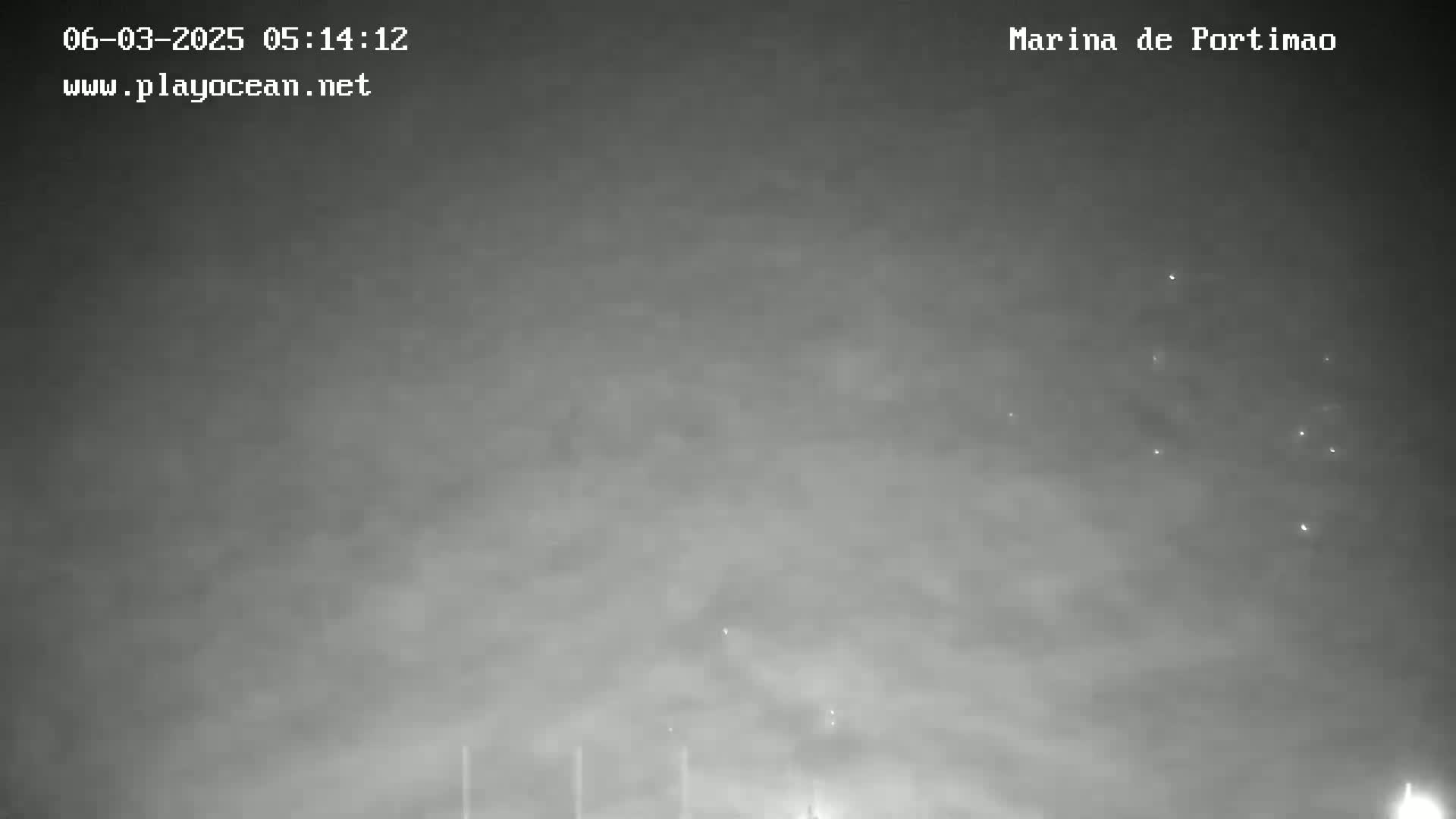 A nighttime, overcast sky with a few faint lights visible in the distance.