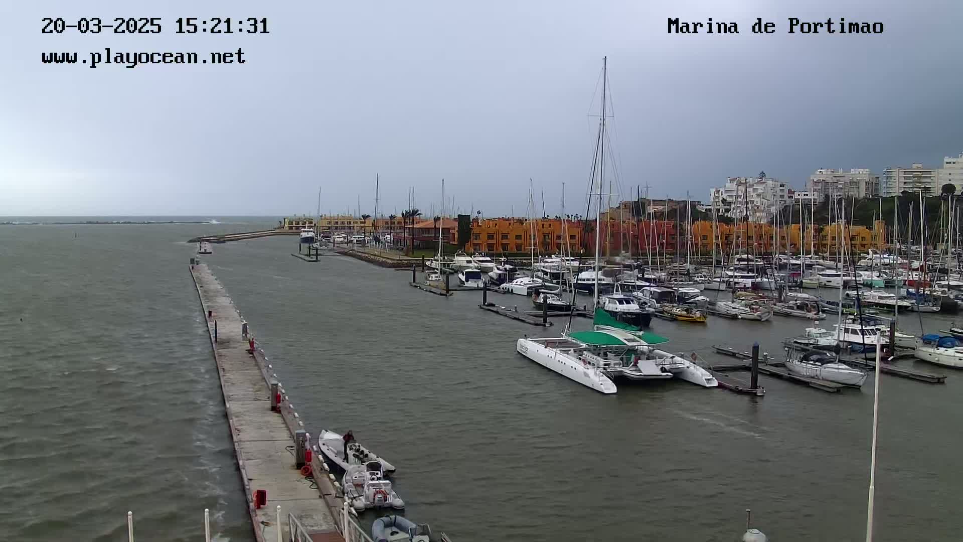 A marina filled with numerous boats and yachts under an overcast sky.