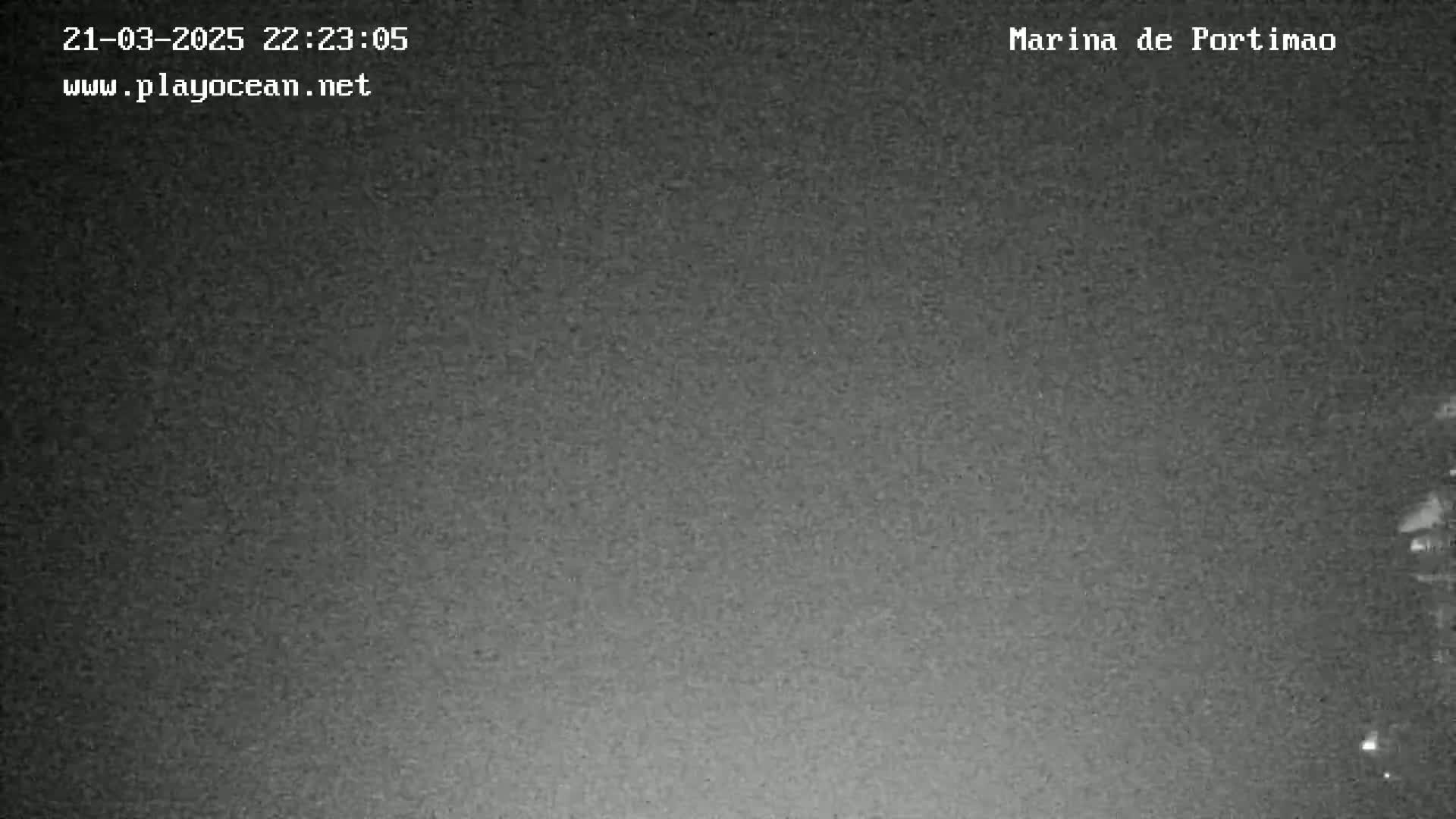 A grainy, dark nighttime image shows a mostly obscured view of a possibly waterfront scene.