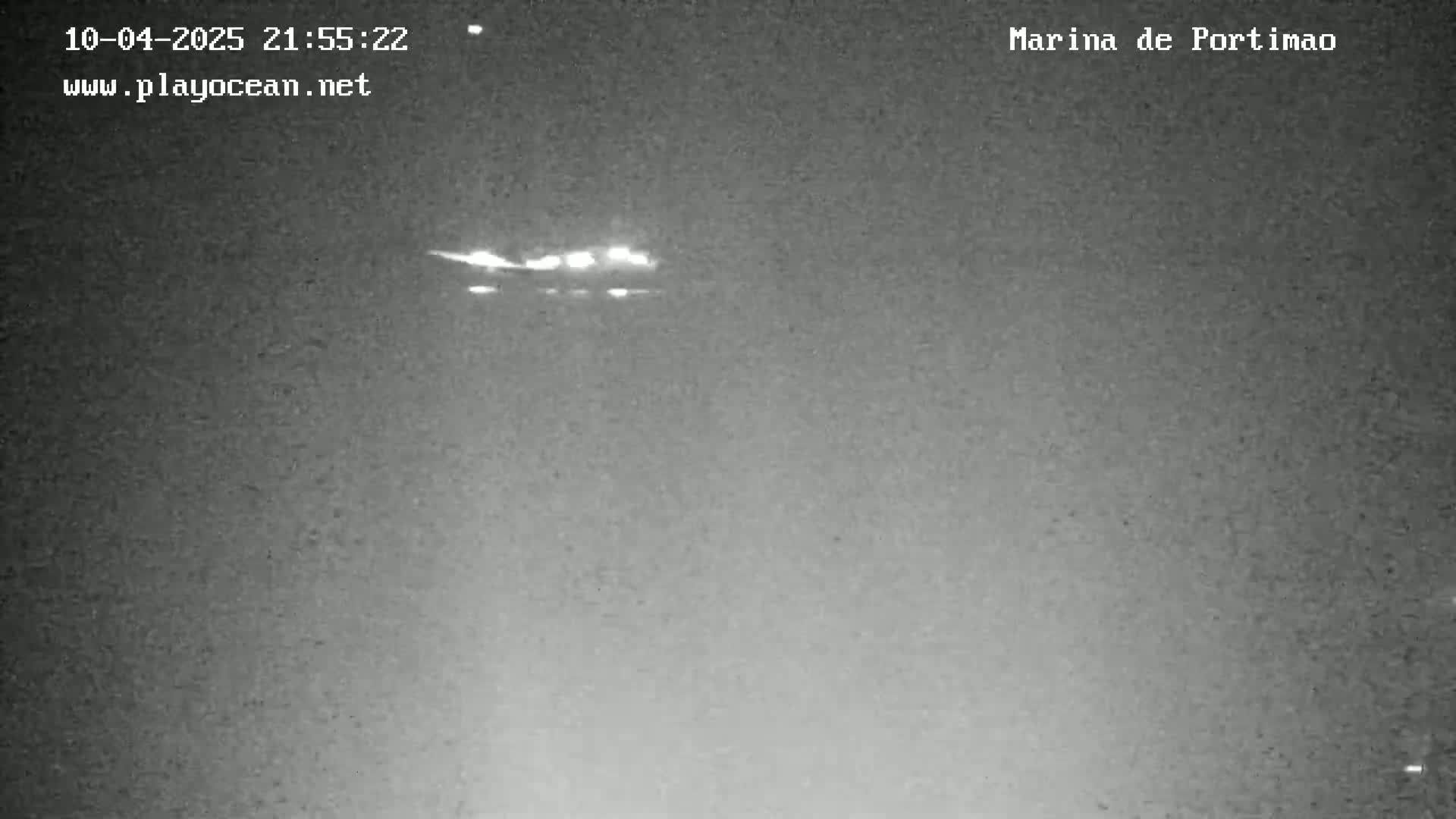 A nighttime, low-light image shows a blurry, bright light source in the sky.