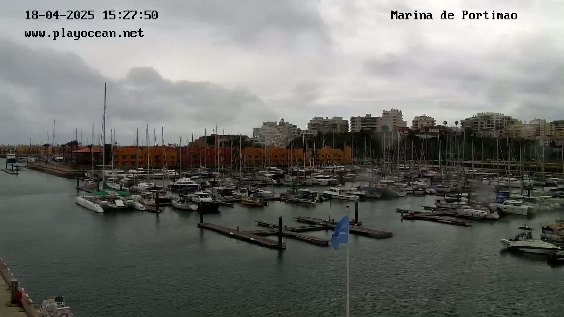 A marina filled with numerous boats and yachts under a cloudy sky.