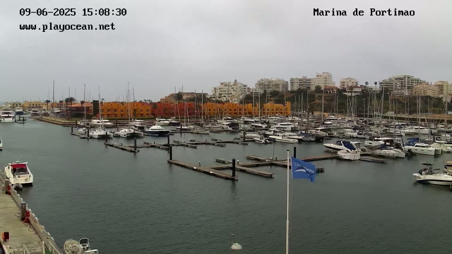 A marina filled with numerous boats on a cloudy day.